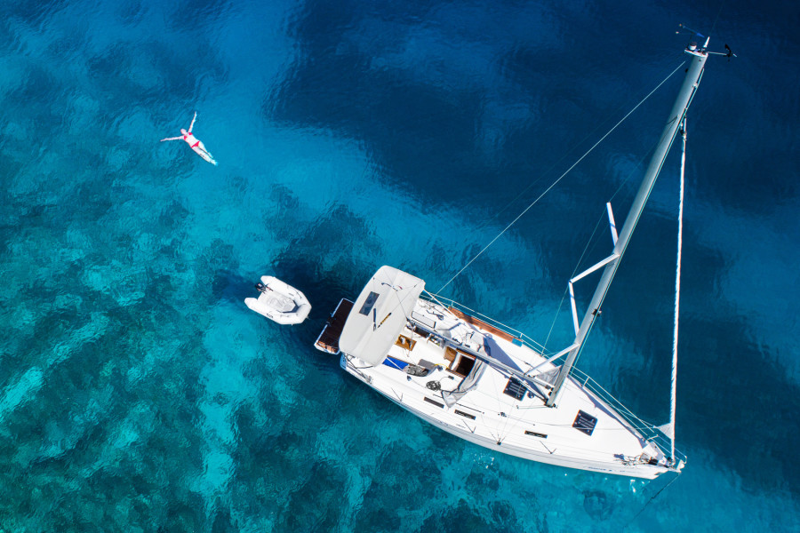 yacht and swimming woman and clear water - caribbean paradise