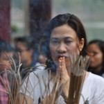 Donna in preghiera ad Hanoi